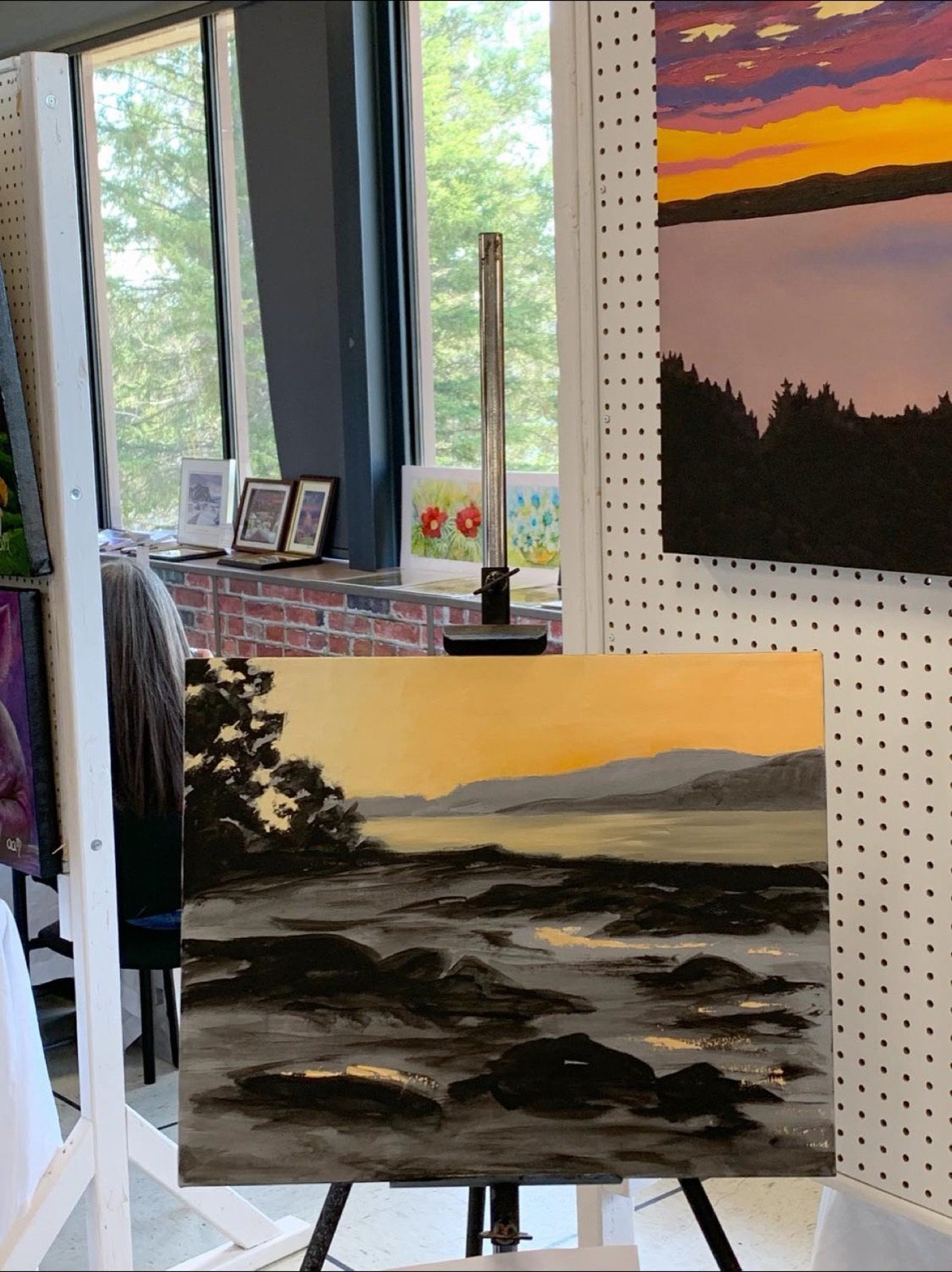 Toile de rive rocheuse au coucher du soleil sur un chevalet, dans l'atelier