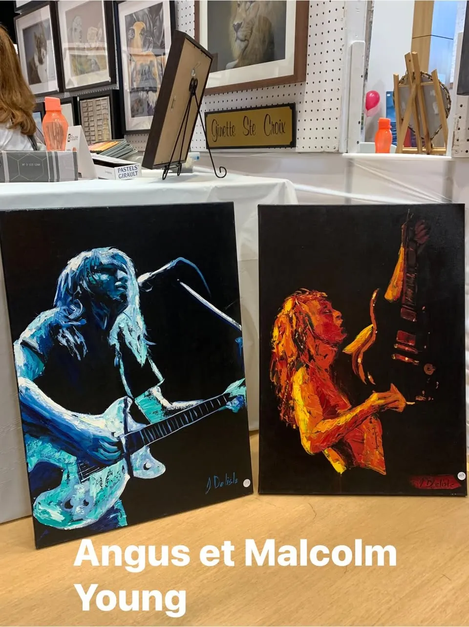 Deux toiles d'Angus et Malcolm Young sur scène, dans des tons bleus et orangés