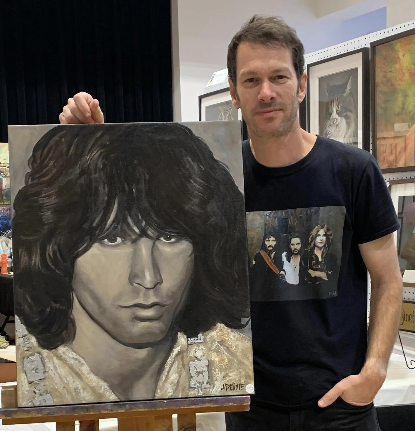 Jean Delisle tient un grand portrait en noir et blanc de Jim Morrison à son kiosque