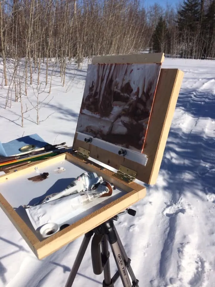 Chevalet portable ouvert avec palette et pinceaux, toile en cours, dans la neige