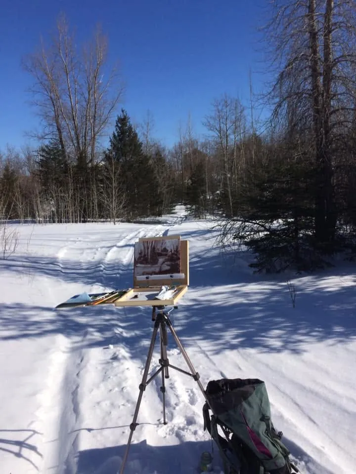 Le chevalet de plein air face à un paysage d'hiver, arbres et neige au soleil