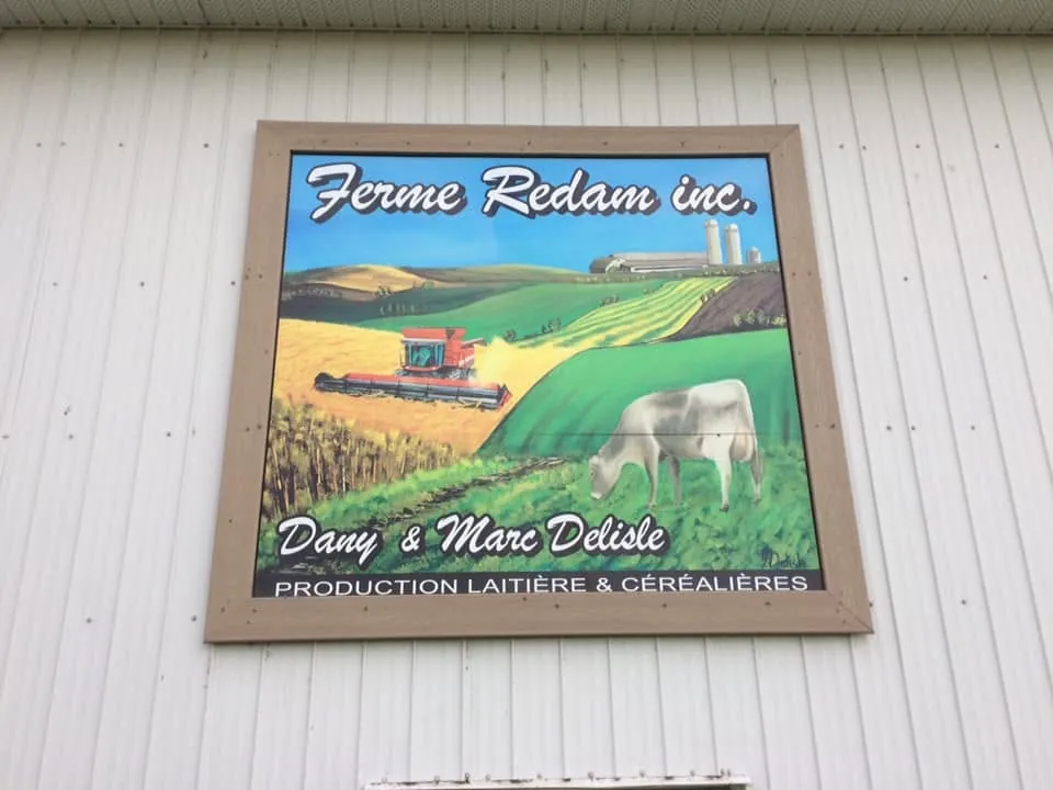 Enseigne de la ferme Redam sur le mur d'un bâtiment de ferme : peinture de champs et de bâtiments agricoles