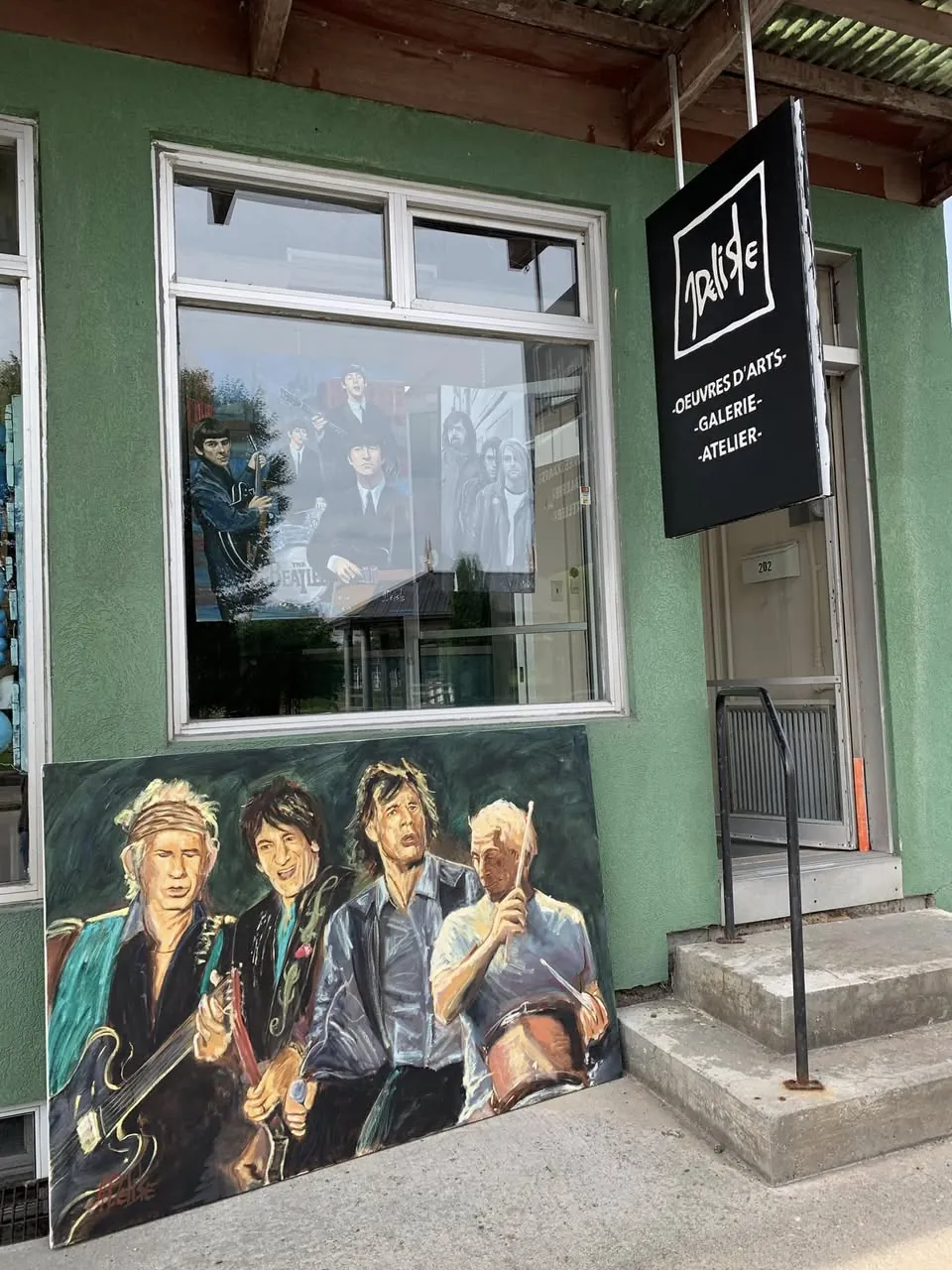 Grande toile des Rolling Stones appuyée devant la galerie, sur le trottoir